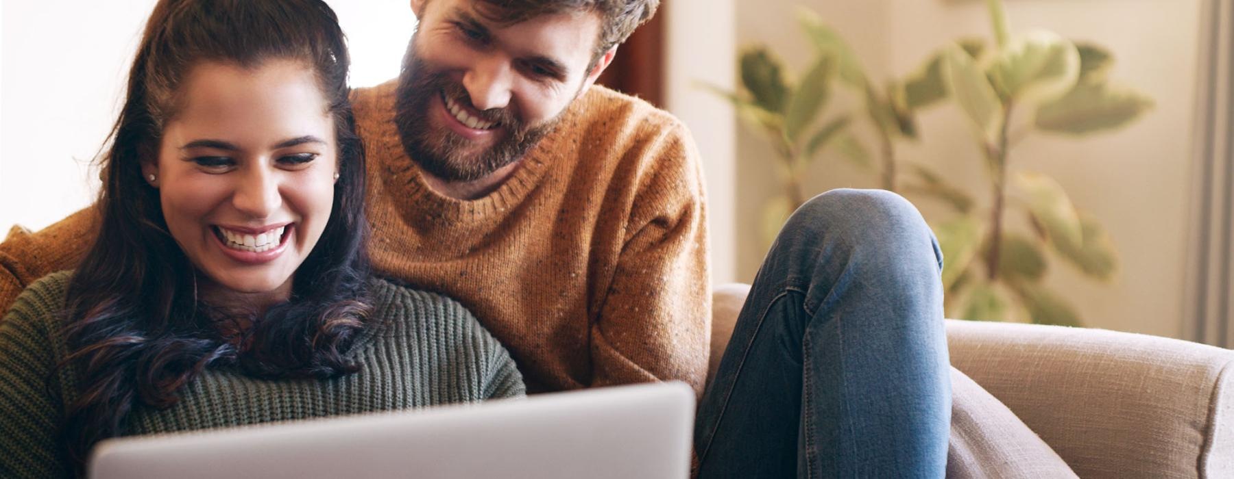 a man and a woman looking at a laptop