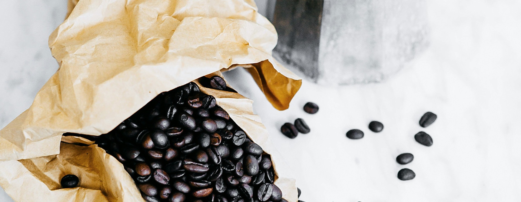 Coffee beans next to a percolator